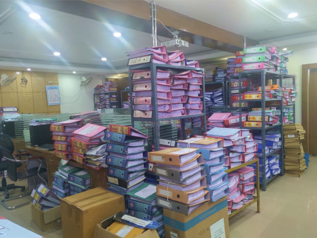 Shelves and stacks of government files in an office record room.